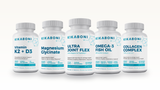 Bone & Joint Stack: front view of five white Kikaboni supplement bottles lined up on a light background.